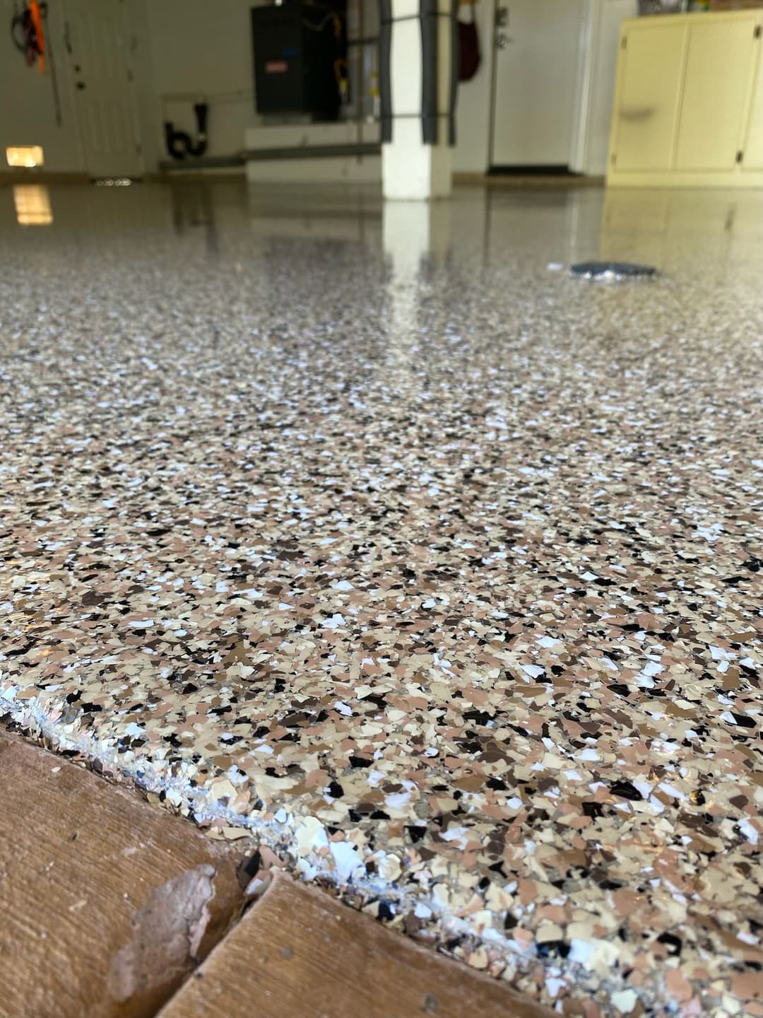 Close-up of a polished garage floor with a speckled epoxy finish. Bright, clean, and durable surface.