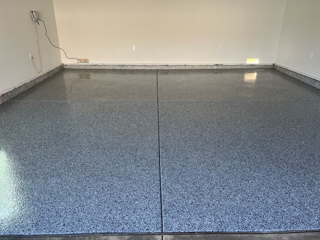 Newly coated gray epoxy garage floor with a glossy finish and speckled texture.