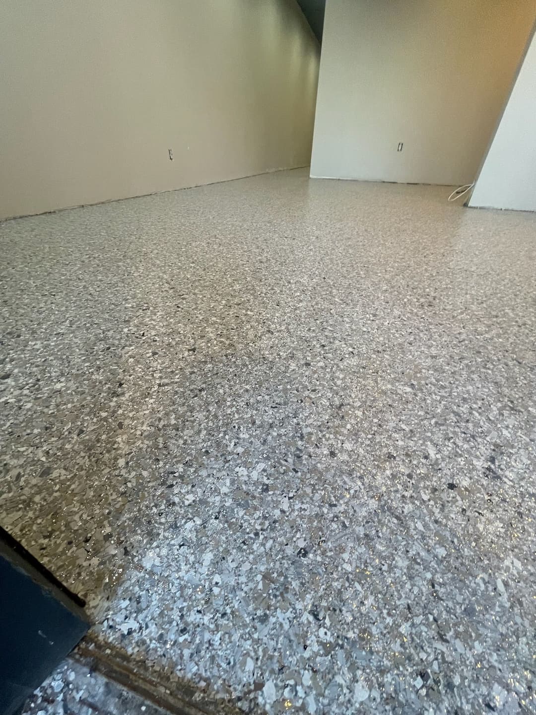 Polished concrete floor in a spacious, empty room with neutral walls.