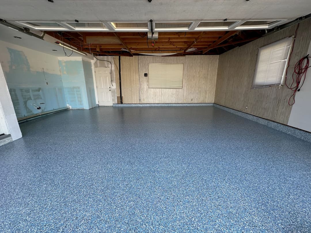 Clean, newly finished garage interior with blue epoxy floor and white walls.