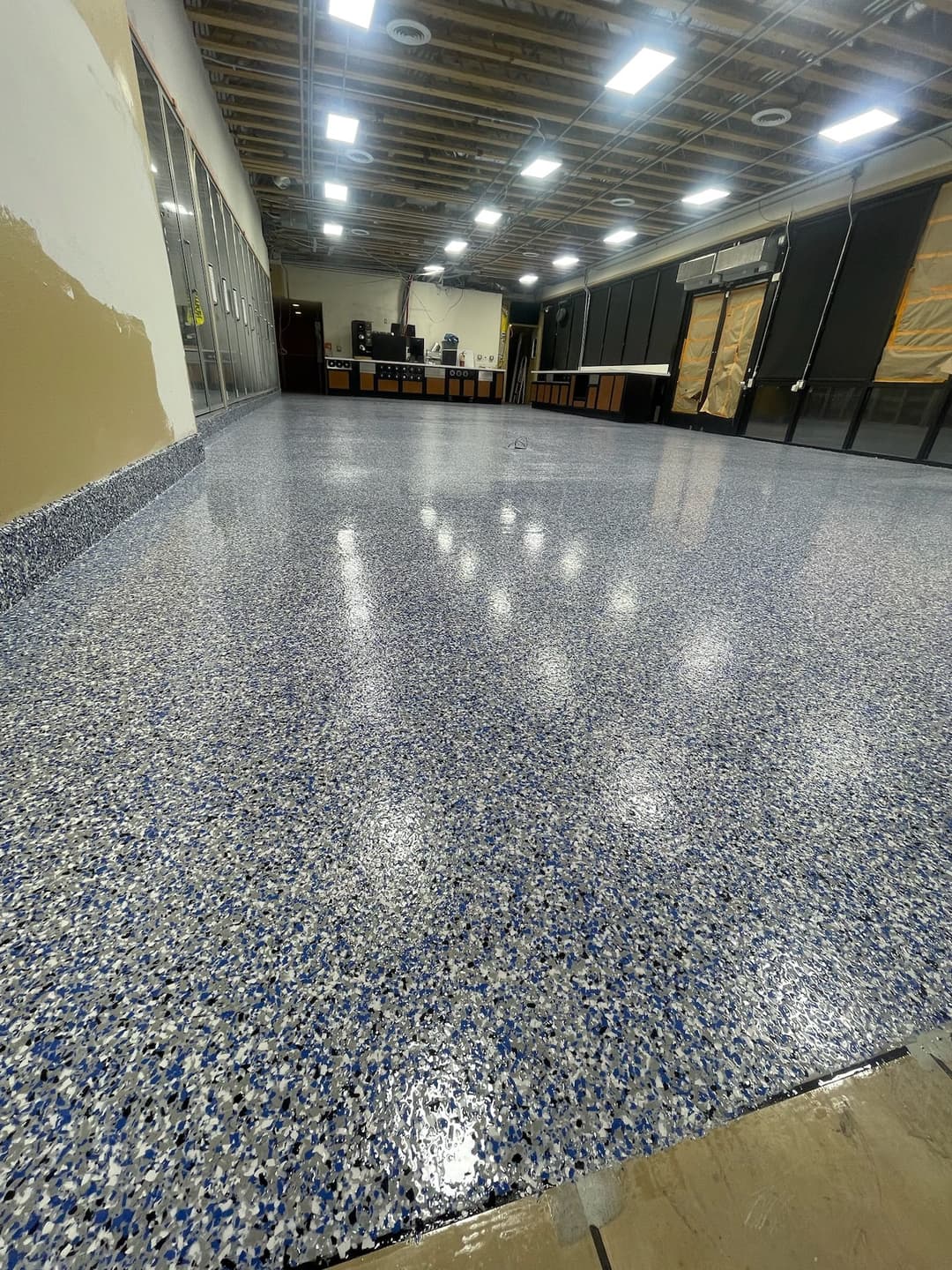 Newly installed blue and gray epoxy floor in a spacious commercial interior.