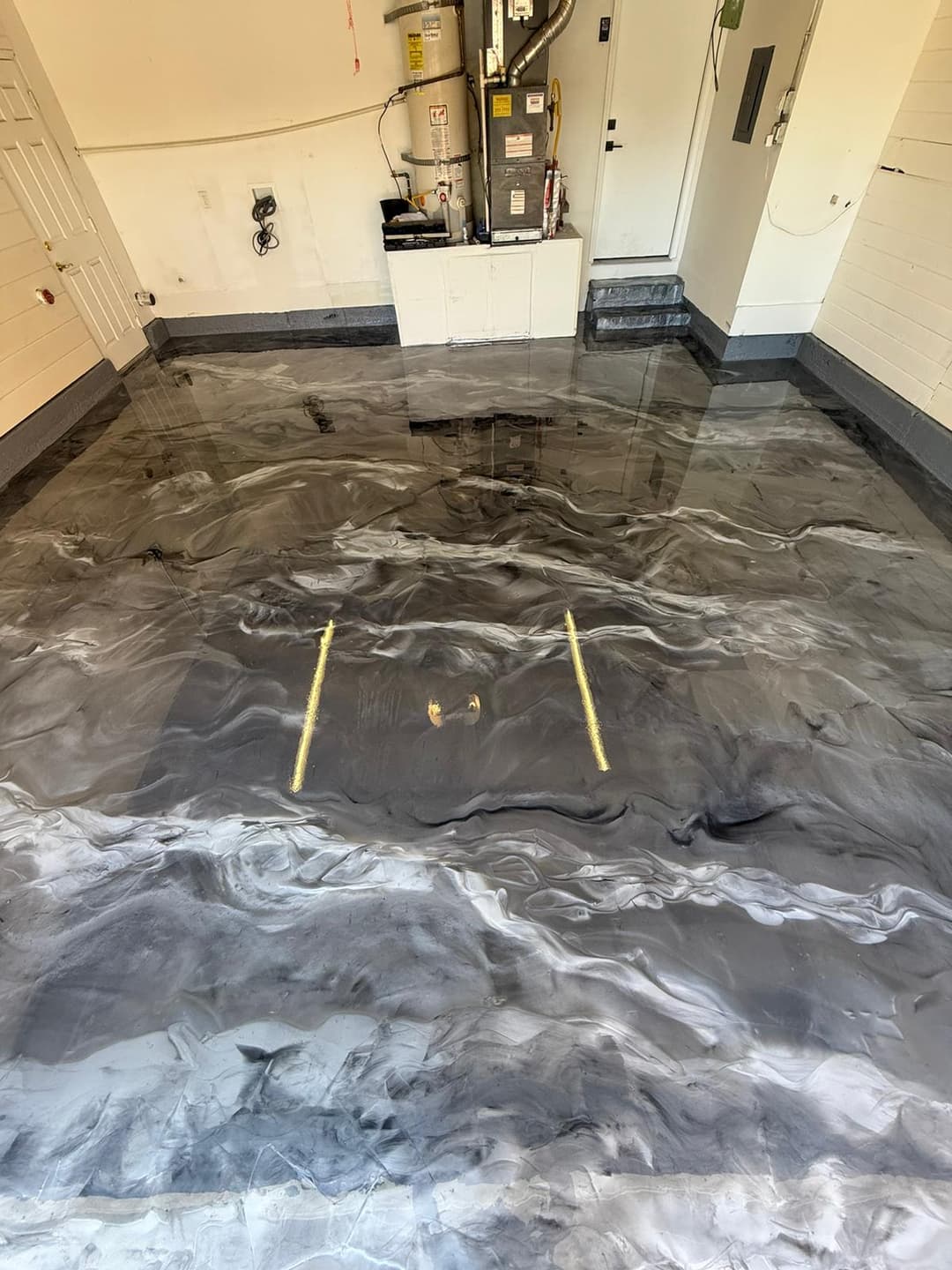 Stylish epoxy garage floor with a marble finish in gray and black hues.
