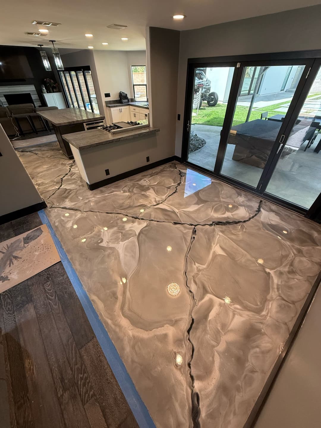 Polished epoxy floor with a marble-like design in a modern living space. Sunlight reflects off the surface.
