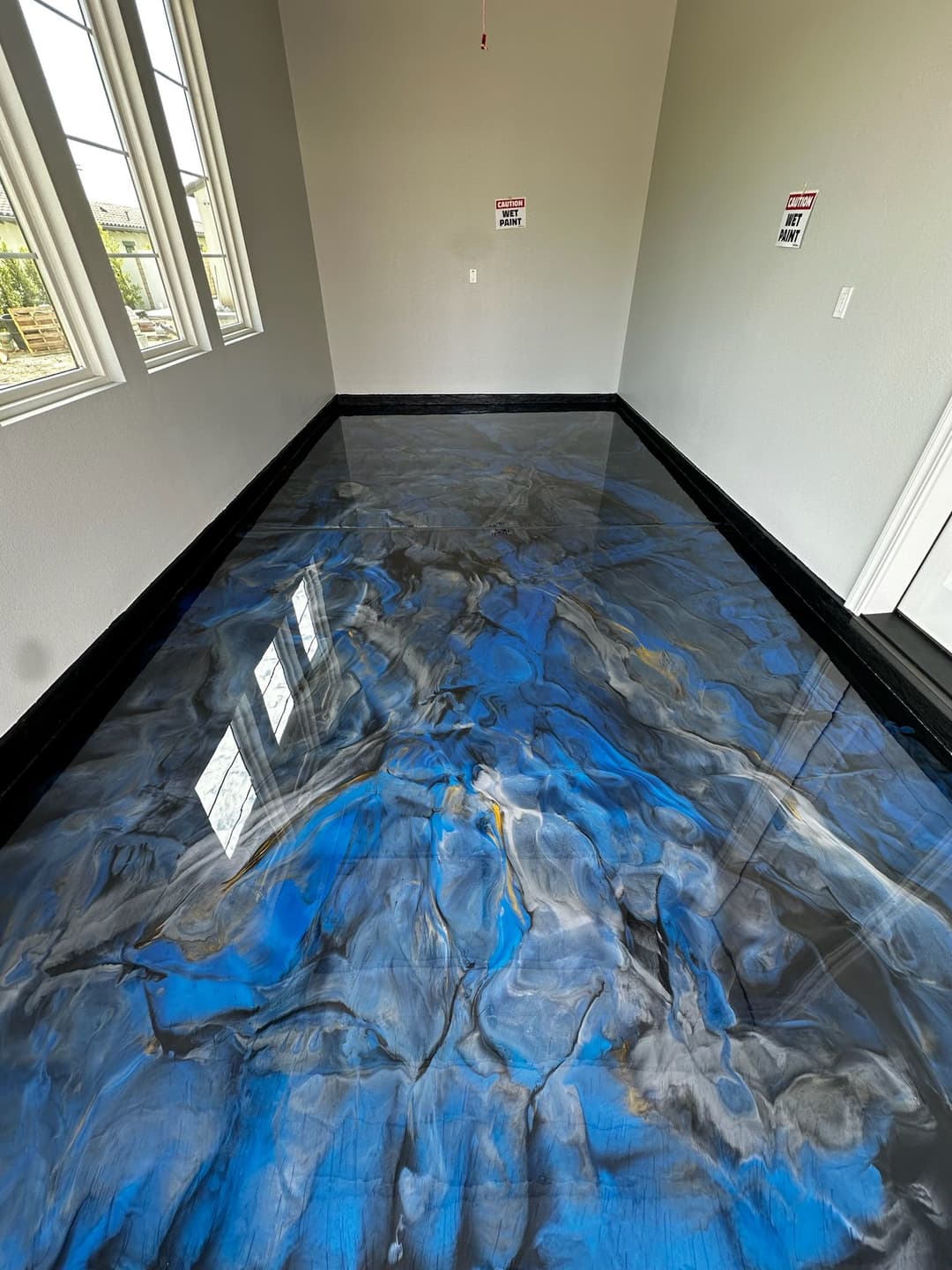 Blue and gray epoxy resin floor with a glossy finish in a well-lit room.