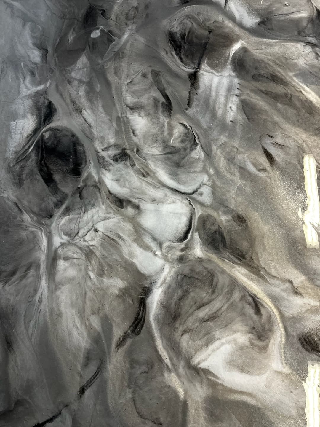 Abstract black and white fluid art with swirling patterns and textures.