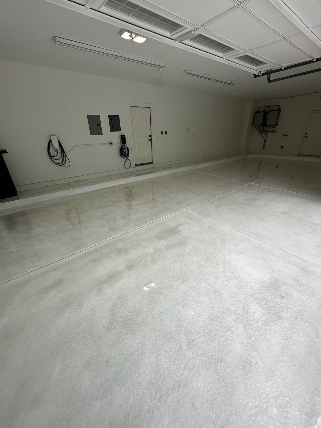 Clean and empty garage with polished concrete floor and electrical panels on the wall.